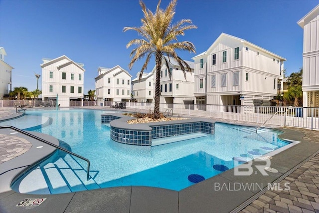 pool featuring a patio area, fence, and a residential view