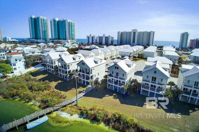 drone / aerial view featuring a city view and a water view