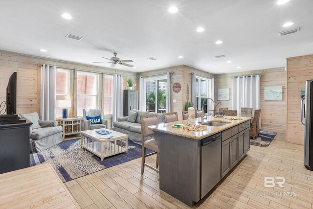 487 E 1st Ave Unit F, Gulf Shores, AL 36542 - kitchen with open floor plan, appliances with stainless steel finishes, wood walls, and a sink