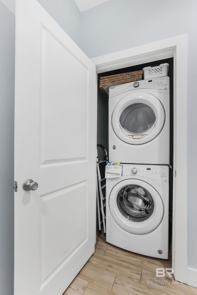 487 E 1st Ave Unit F, Gulf Shores, AL 36542 - laundry room featuring light wood-type flooring, stacked washer and clothes dryer, and laundry area