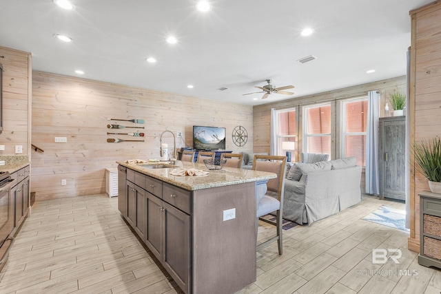 487 E 1st Ave Unit F, Gulf Shores, AL 36542 - kitchen featuring a ceiling fan, light wood-style floors, visible vents, a kitchen bar, and a sink