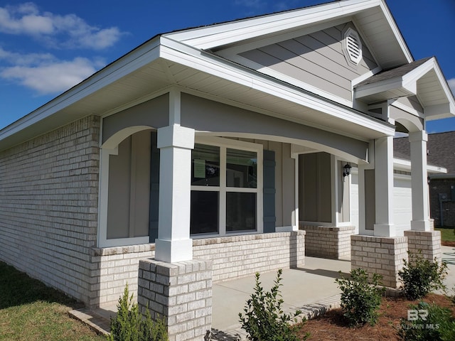 exterior space with covered porch and a garage