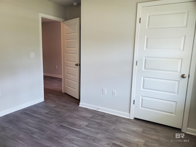 unfurnished bedroom with dark hardwood / wood-style floors