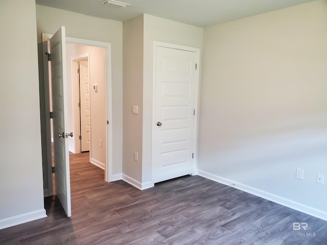 unfurnished bedroom featuring dark hardwood / wood-style flooring