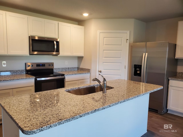 kitchen with white cabinets, sink, dark hardwood / wood-style floors, an island with sink, and appliances with stainless steel finishes