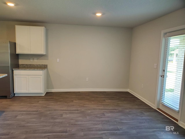 unfurnished dining area featuring dark hardwood / wood-style flooring