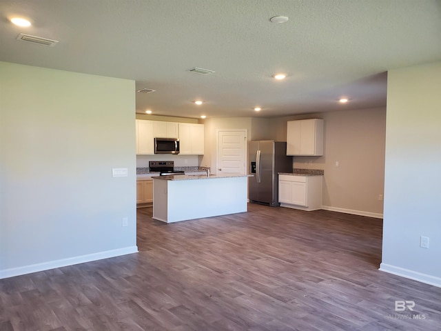 kitchen featuring white cabinets, dark hardwood / wood-style flooring, an island with sink, and appliances with stainless steel finishes