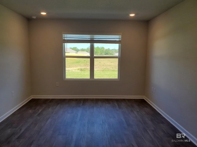 empty room with dark hardwood / wood-style flooring