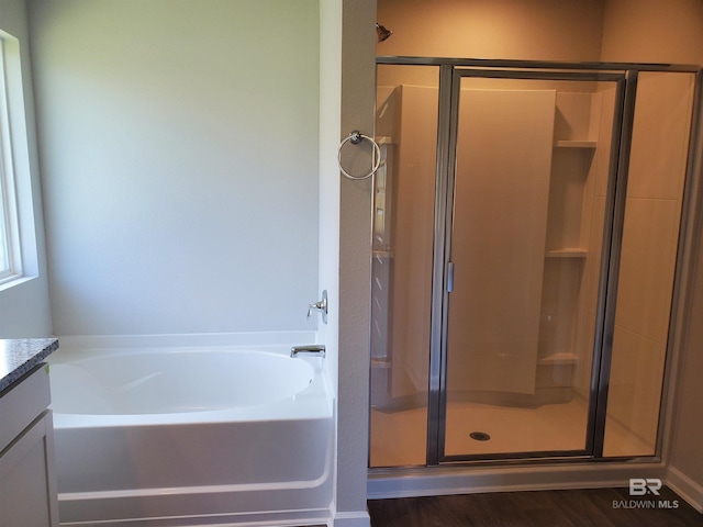 bathroom featuring vanity, plus walk in shower, and hardwood / wood-style flooring