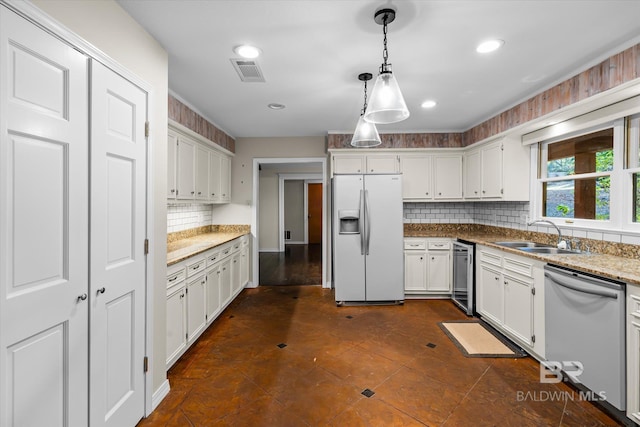 kitchen featuring light stone counters, stainless steel dishwasher, hanging light fixtures, white cabinets, and white fridge with ice dispenser