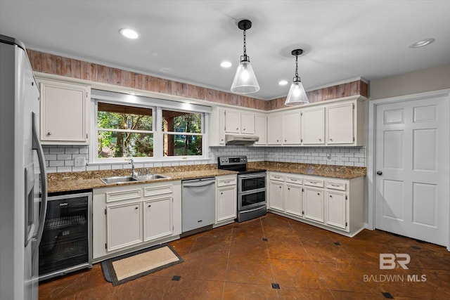 kitchen with appliances with stainless steel finishes, sink, decorative light fixtures, white cabinetry, and wine cooler