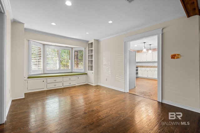 unfurnished bedroom with hardwood / wood-style flooring, ensuite bath, and crown molding