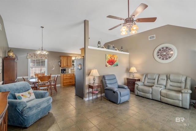 living room featuring ceiling fan with notable chandelier, light tile patterned floors, and vaulted ceiling