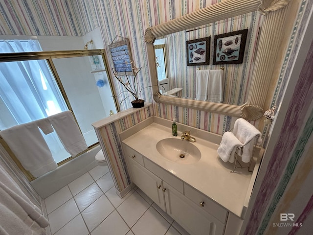 bathroom featuring wallpapered walls, bath / shower combo with glass door, toilet, tile patterned floors, and vanity