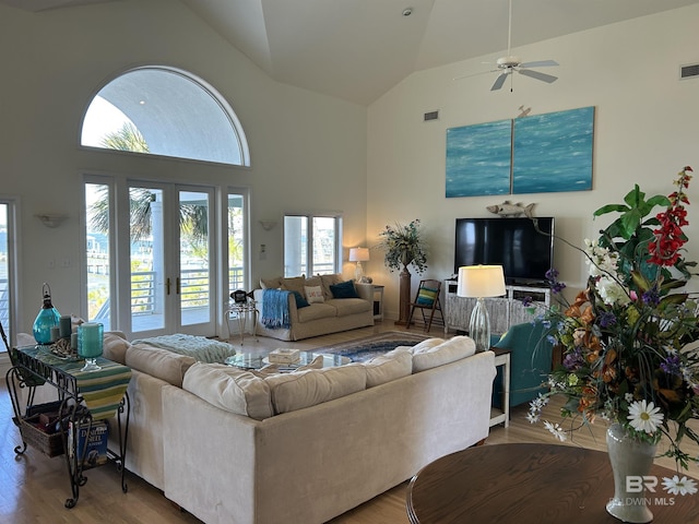 living room featuring high vaulted ceiling, french doors, visible vents, and wood finished floors