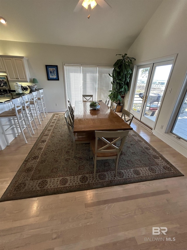 dining room featuring a ceiling fan, lofted ceiling, and light wood-style flooring