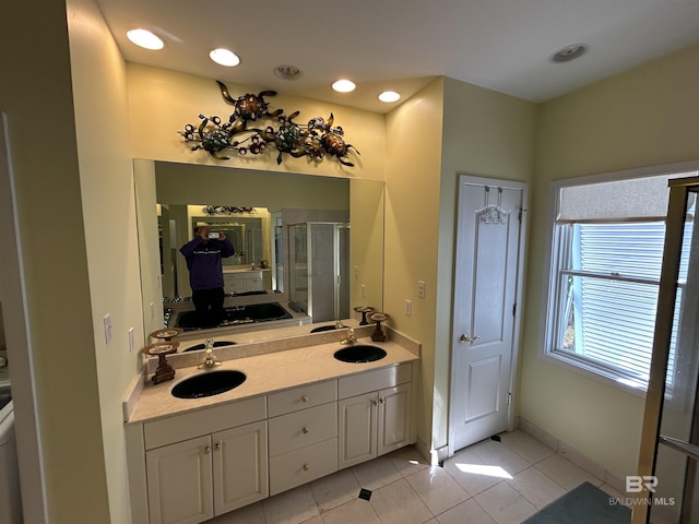 bathroom featuring tile patterned flooring, a sink, baseboards, a shower stall, and double vanity