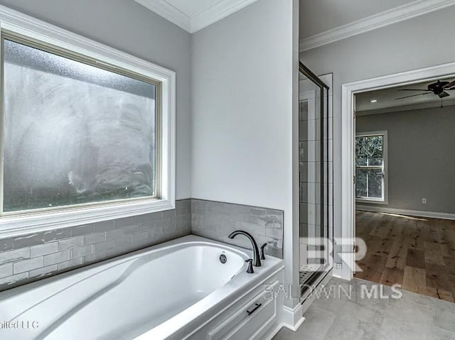 bathroom featuring a garden tub, a ceiling fan, a shower stall, and ornamental molding
