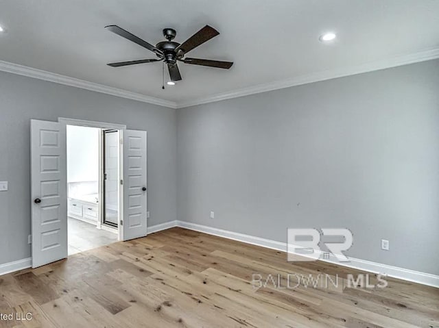 spare room featuring crown molding, wood finished floors, baseboards, and ceiling fan