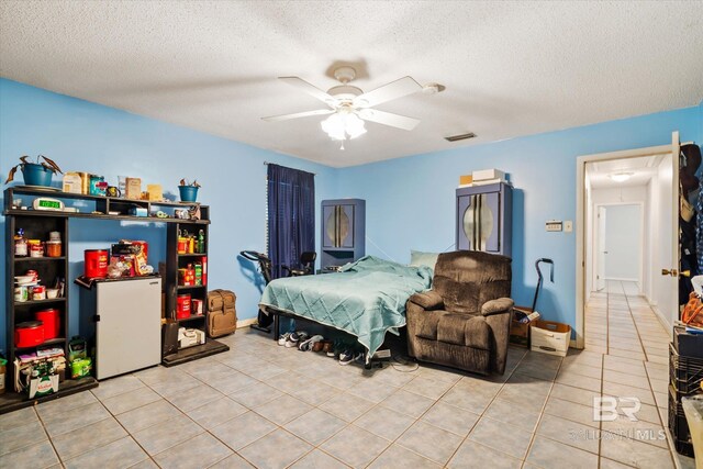 tiled bedroom featuring ceiling fan, visible vents, and a textured ceiling