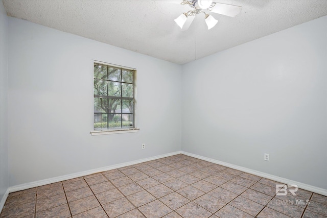 empty room featuring a textured ceiling, ceiling fan, and light tile patterned floors