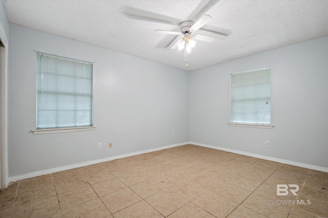 unfurnished room with ceiling fan, light tile patterned floors, a textured ceiling, and a healthy amount of sunlight