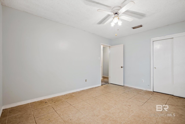 unfurnished bedroom with visible vents, baseboards, a textured ceiling, and a closet