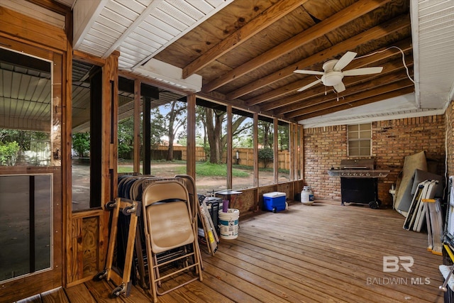 sunroom / solarium featuring beamed ceiling, wood ceiling, and a ceiling fan