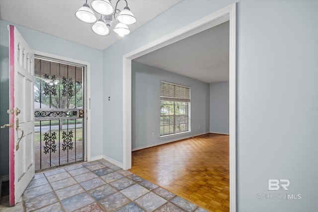 interior space with light parquet floors and an inviting chandelier