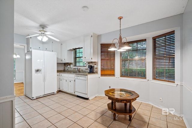 kitchen with ceiling fan with notable chandelier, backsplash, white appliances, white cabinets, and light tile patterned flooring