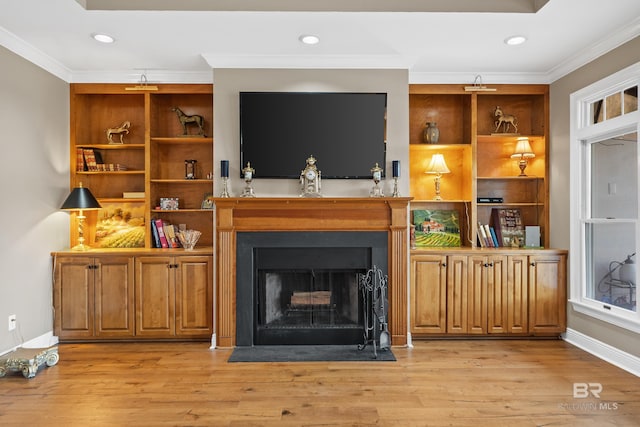 living room featuring light wood-type flooring, a fireplace with flush hearth, baseboards, and ornamental molding