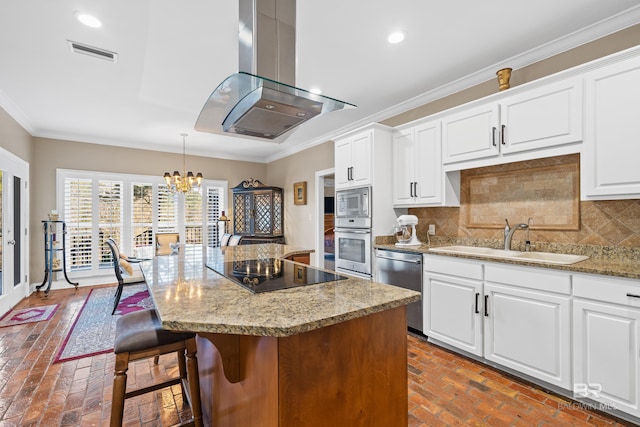 kitchen featuring visible vents, brick floor, a sink, appliances with stainless steel finishes, and island range hood