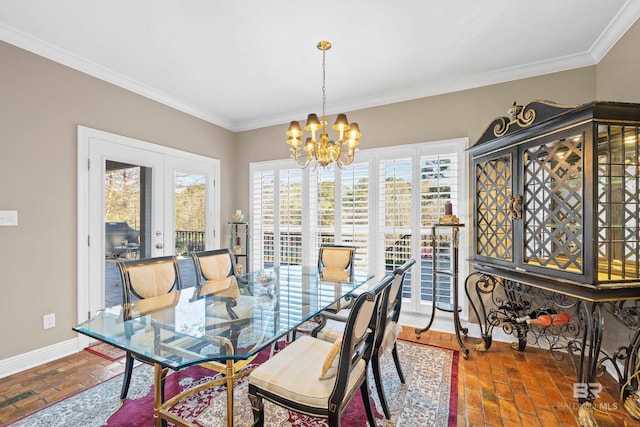 dining area featuring baseboards, brick floor, french doors, crown molding, and a chandelier