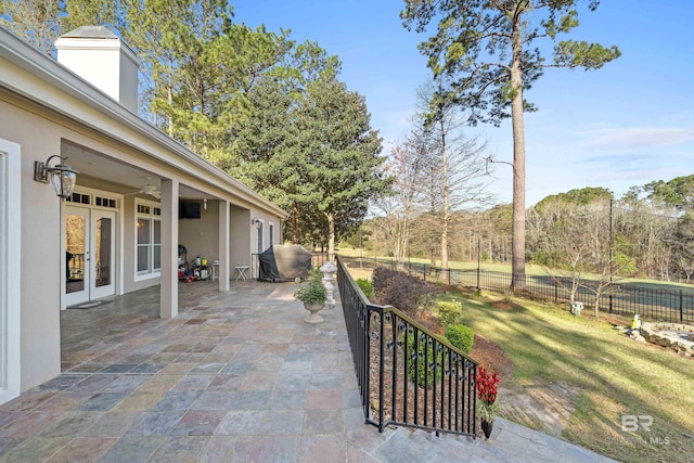 view of patio featuring french doors, a ceiling fan, and a fenced backyard