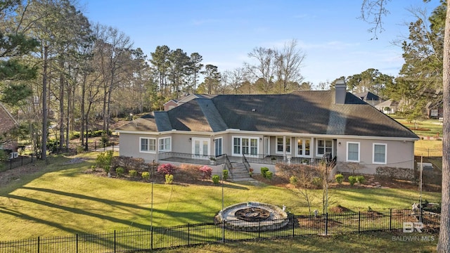 rear view of house featuring fence, stairway, stucco siding, a lawn, and a chimney