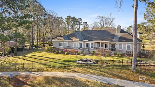 view of front of property featuring a fire pit, fence private yard, a front yard, stucco siding, and a chimney