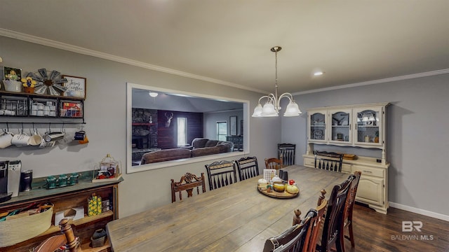 dining space featuring dark hardwood / wood-style flooring, crown molding, and a notable chandelier