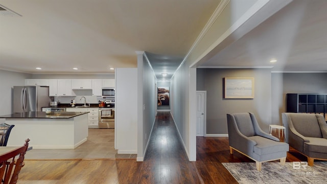 hall featuring sink, crown molding, and hardwood / wood-style flooring