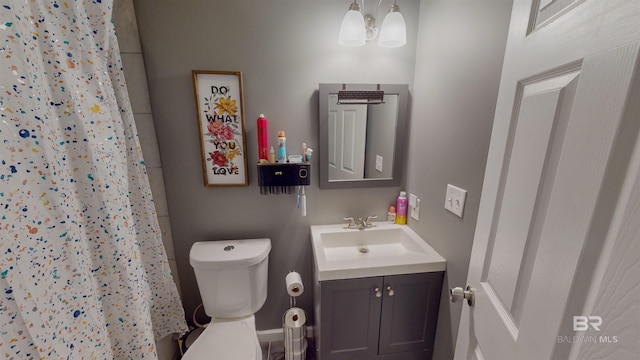 bathroom featuring toilet, vanity, and a shower with shower curtain