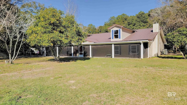 rear view of property featuring a lawn