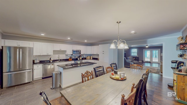 dining area featuring an inviting chandelier, crown molding, and sink