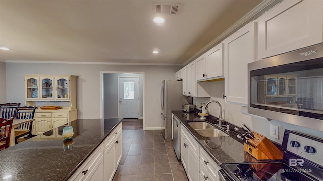 kitchen with sink, white cabinets, appliances with stainless steel finishes, and crown molding