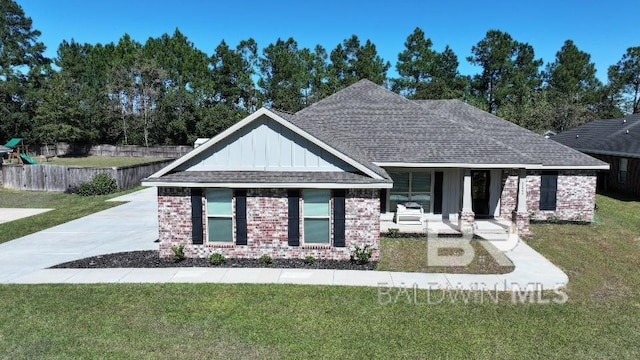view of front of house with a front lawn, brick siding, and board and batten siding