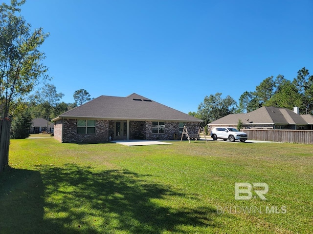 back of house featuring fence, french doors, and a lawn
