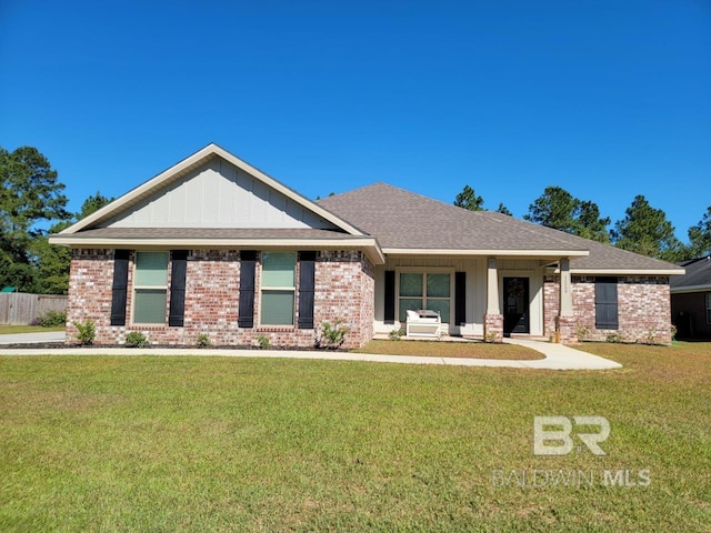 view of front of home with board and batten siding, brick siding, and a front yard