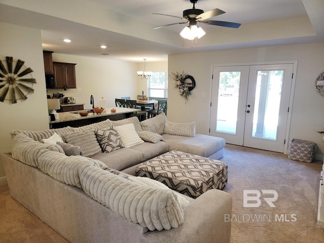 living room featuring light carpet, ceiling fan with notable chandelier, french doors, and recessed lighting