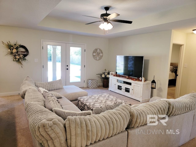 living area featuring light colored carpet, ceiling fan, baseboards, and french doors