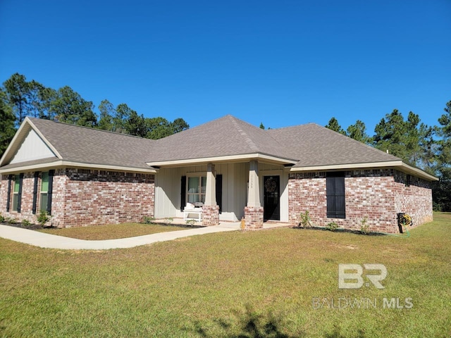 single story home featuring a shingled roof, brick siding, and a front lawn