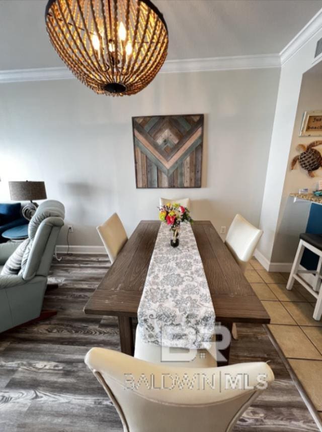 401 E Beach Blvd Unit 507, Gulf Shores, AL 36542 - dining room with crown molding, baseboards, tile patterned floors, and a chandelier