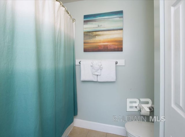 401 E Beach Blvd Unit 507, Gulf Shores, AL 36542 - bathroom with toilet, tile patterned flooring, baseboards, and curtained shower